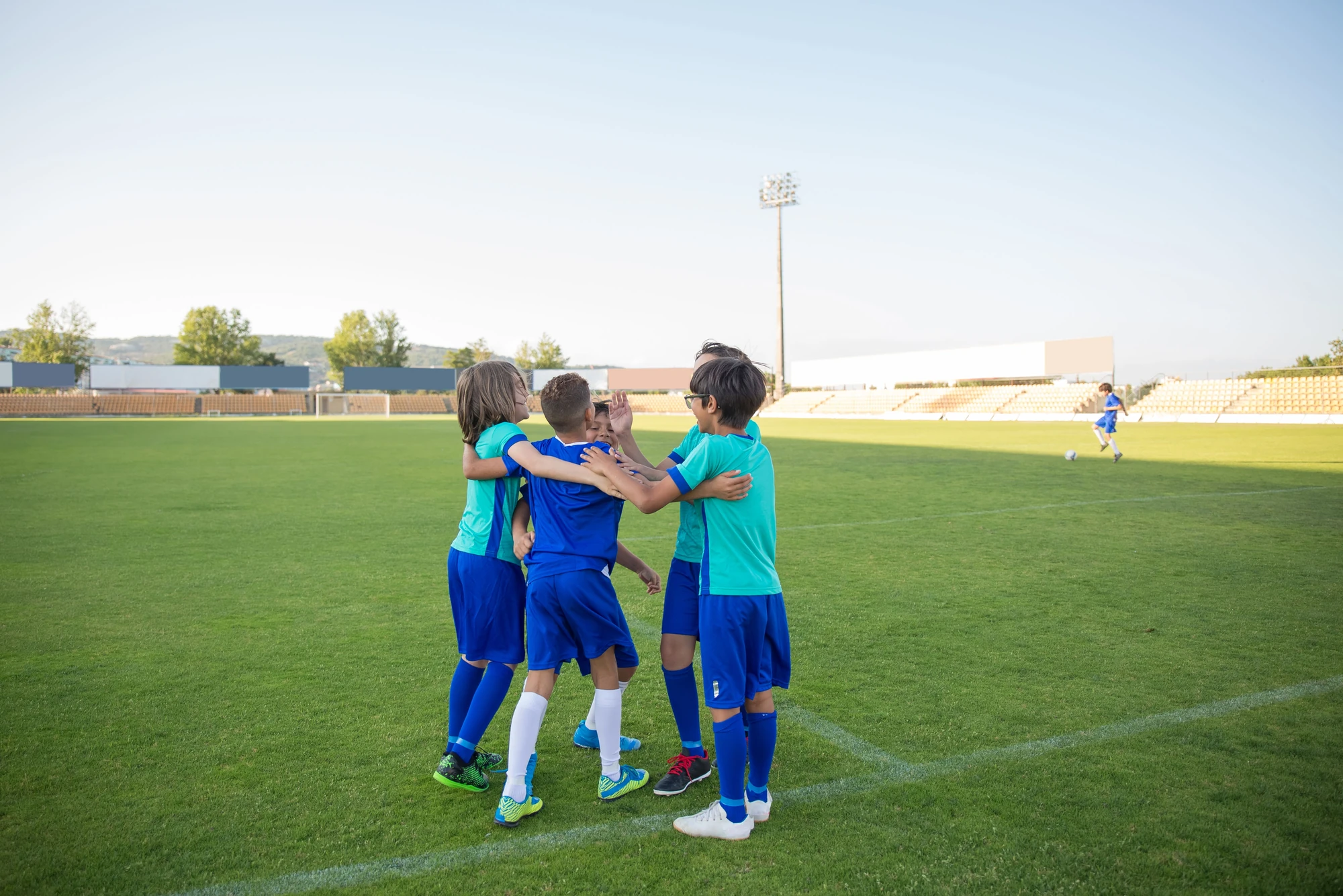 Young soccer teammates celebrating together on a grass field